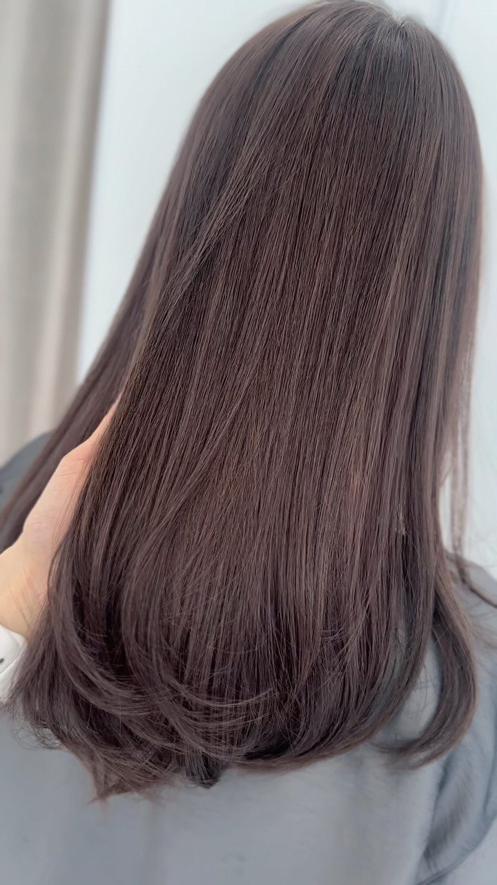 Dark neutral brown hair falls straight down the back with softly curved ends
