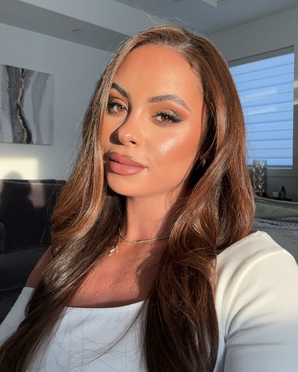 Woman with long, wavy deep golden brown hair and subtle warm highlights