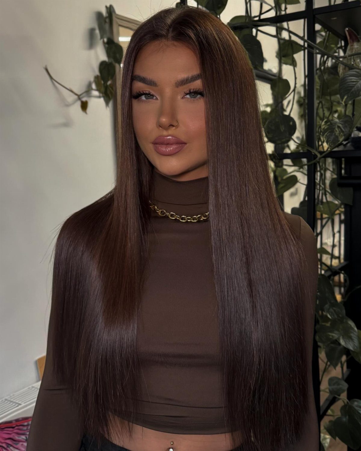 Woman with sleek, nearly black espresso-brown hair parted down the center