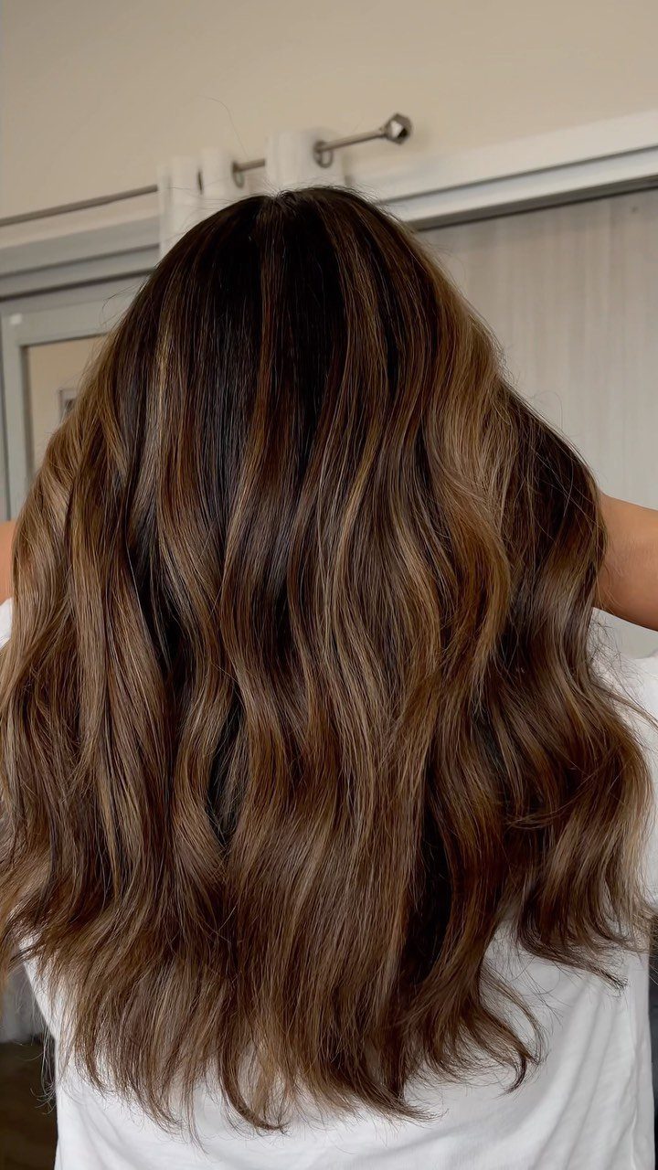 Long wavy brunette hair with subtle warm honey highlights