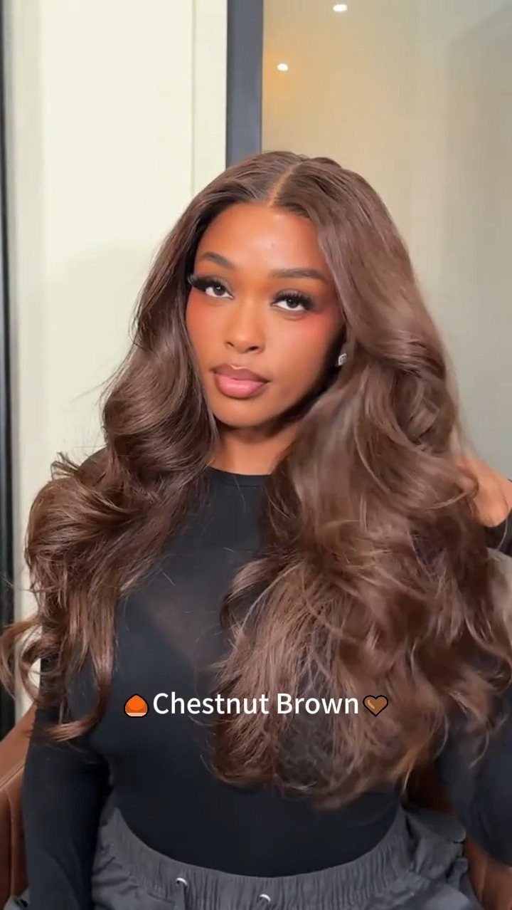 Woman with chestnut-brown layered hair styled in long, voluminous waves