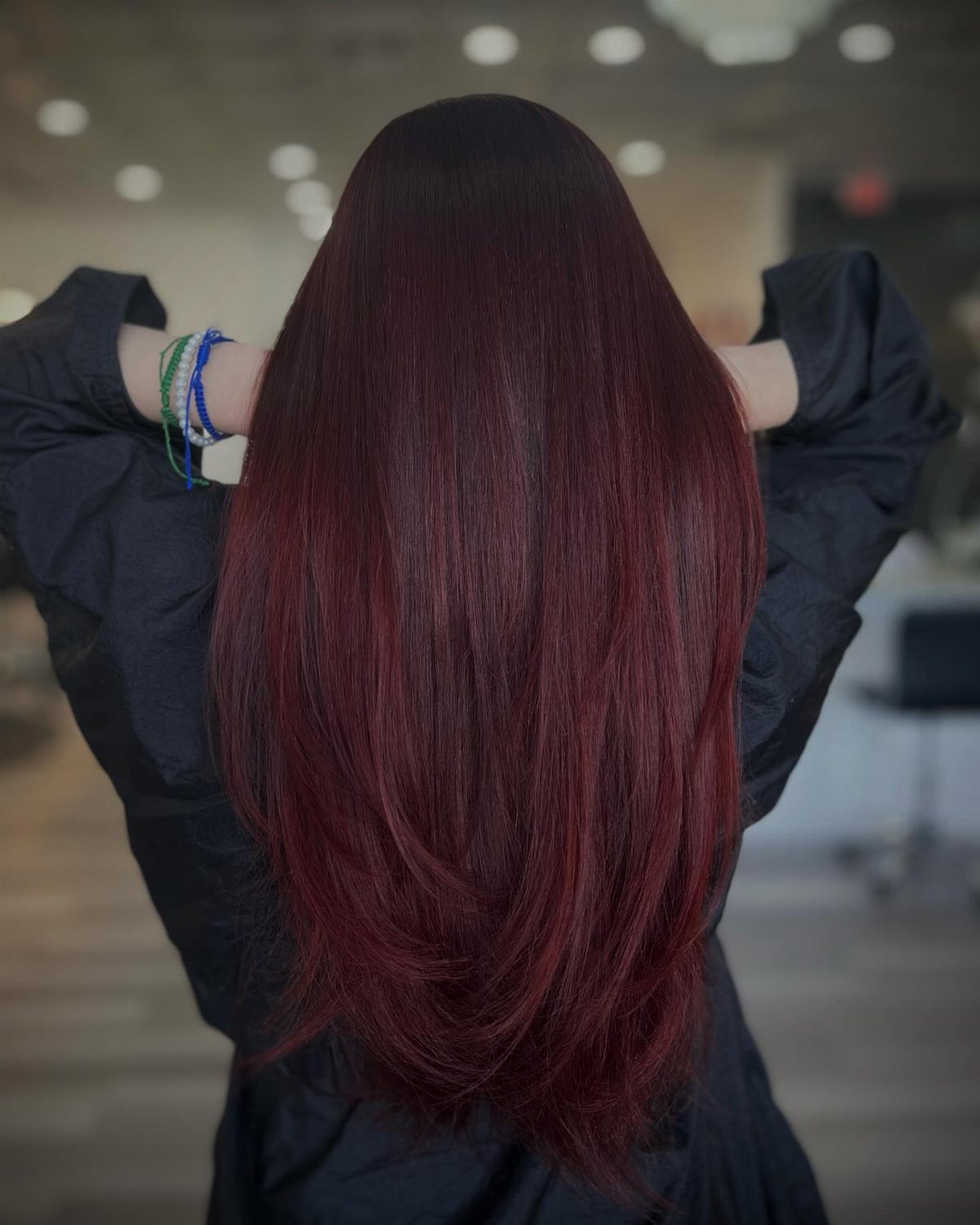 Long glossy hair with nearly black roots and deep burgundy-red lengths