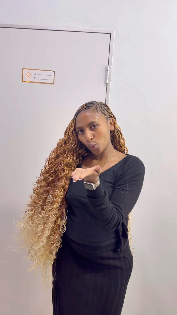 Woman displaying long brown ombré curls with dark roots and lighter ends