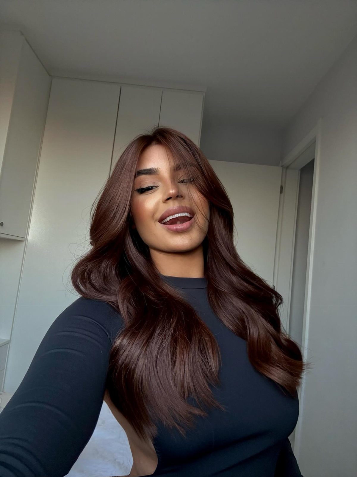Woman with long, warm chocolate brown hair styled in loose waves