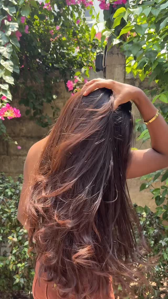 Long dark brown hair with lighter sun-faded ends held outdoors