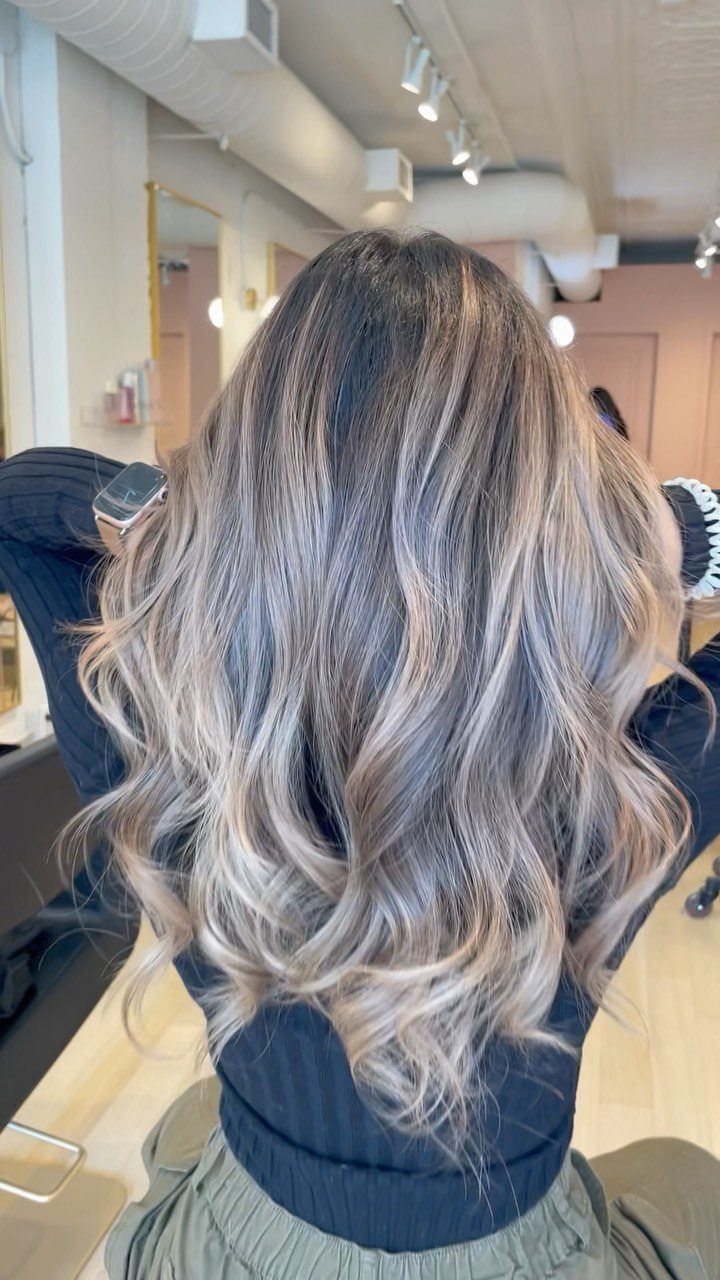 Long wavy brown hair with sandy beige blonde highlights in a salon