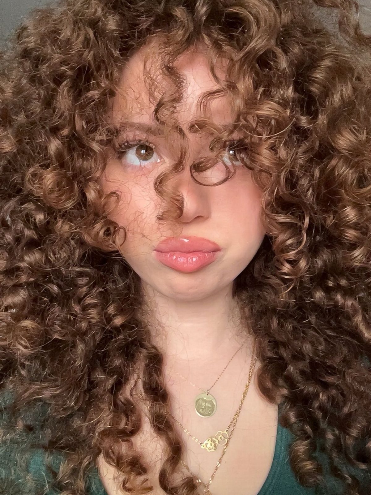 Woman with voluminous dark brown curls showing subtle warm ginger tones