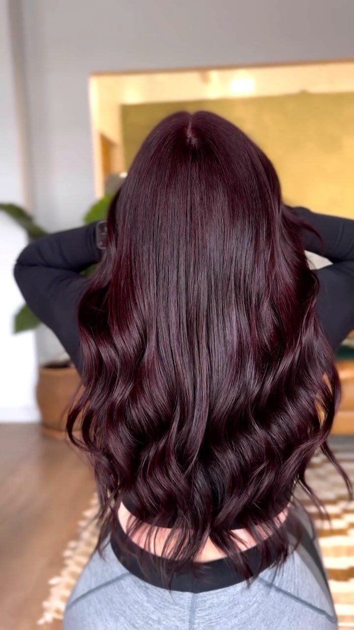 Long wavy brunette hair with subtle burgundy-red tones seen from behind