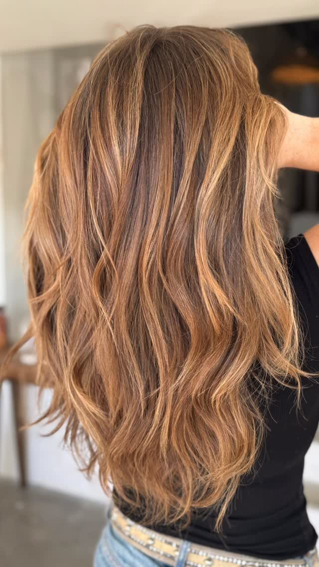 Long wavy brown hair with dimensional caramel and golden highlights