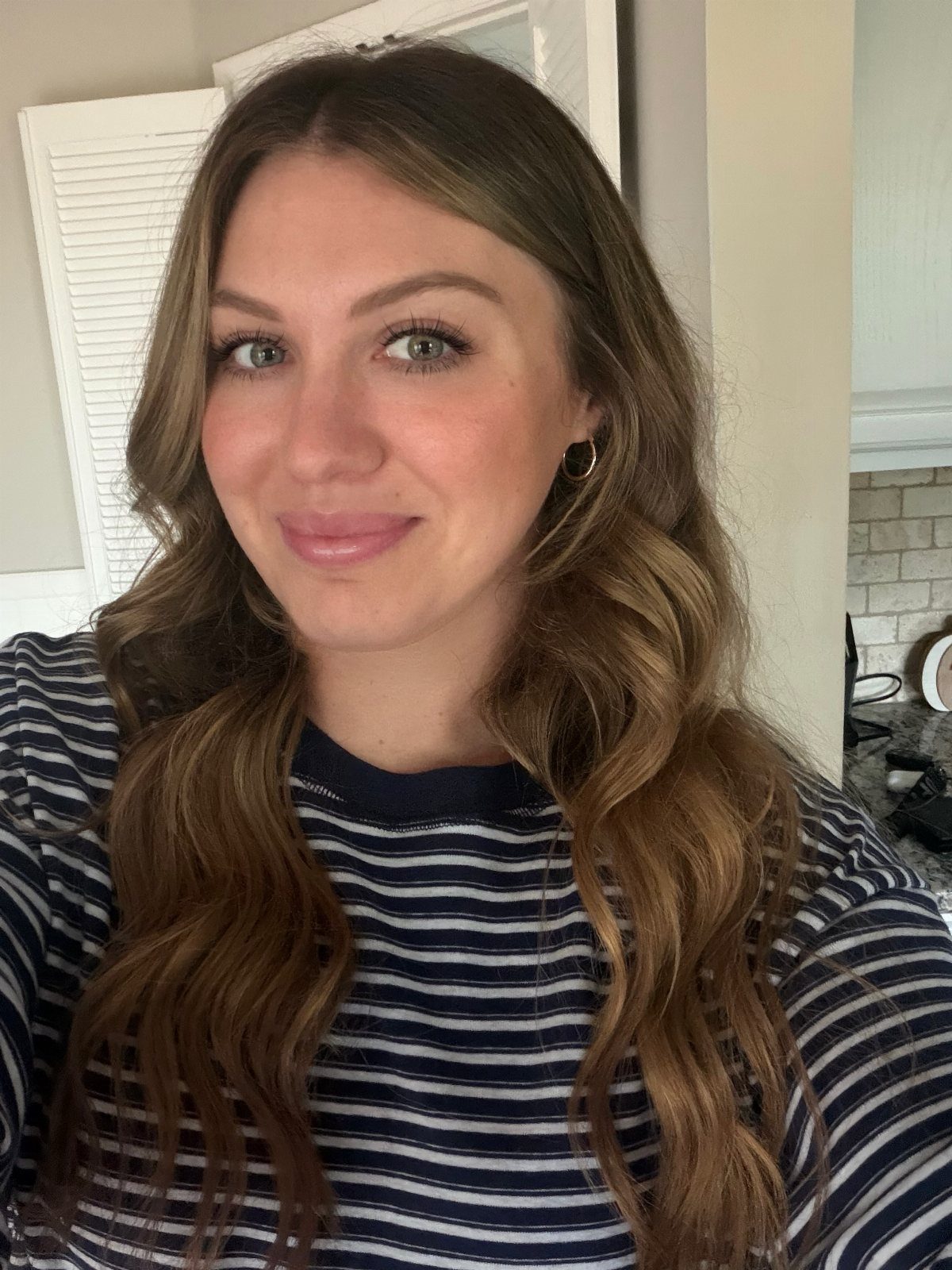 Woman with long wavy honey golden-brown hair and lighter warm strands