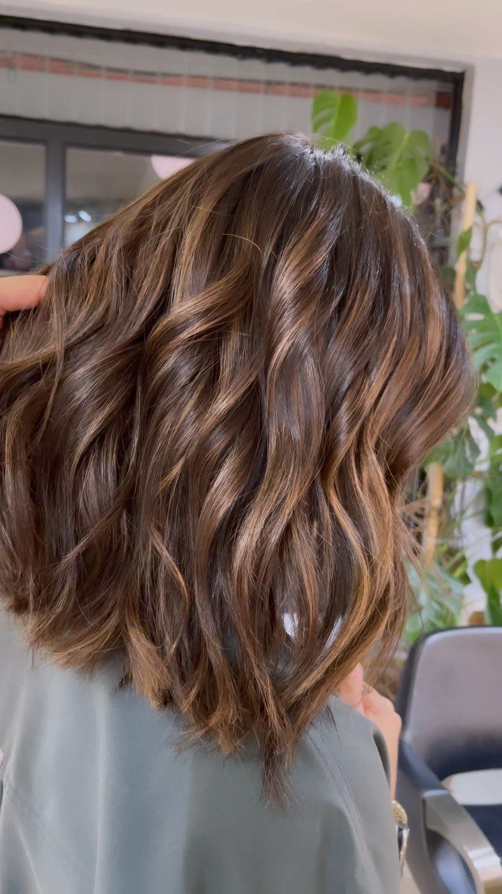 Shoulder-length caramel bronde hair with balayage highlights and loose textured waves