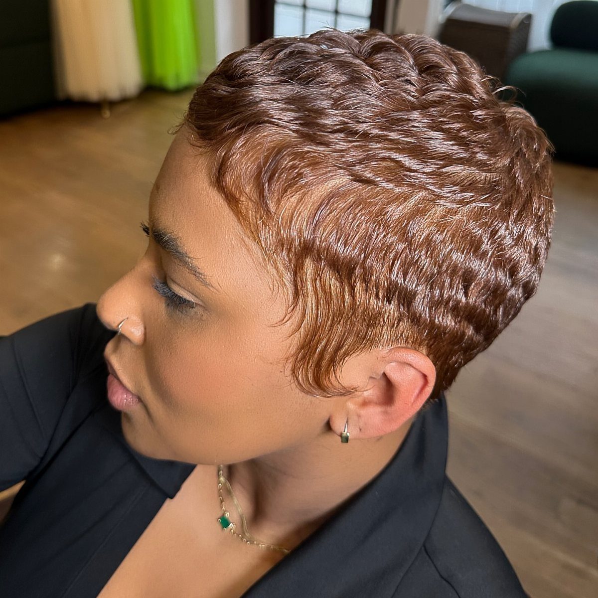 Short wavy copper-brown pixie cut styled close around the head
