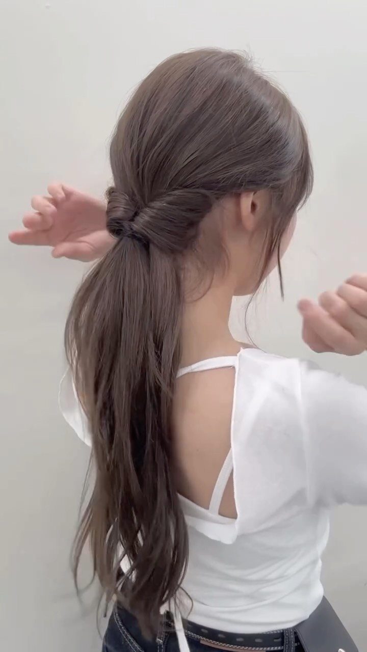 Long layered brown hair gathered into a low ponytail with loose cascading ends