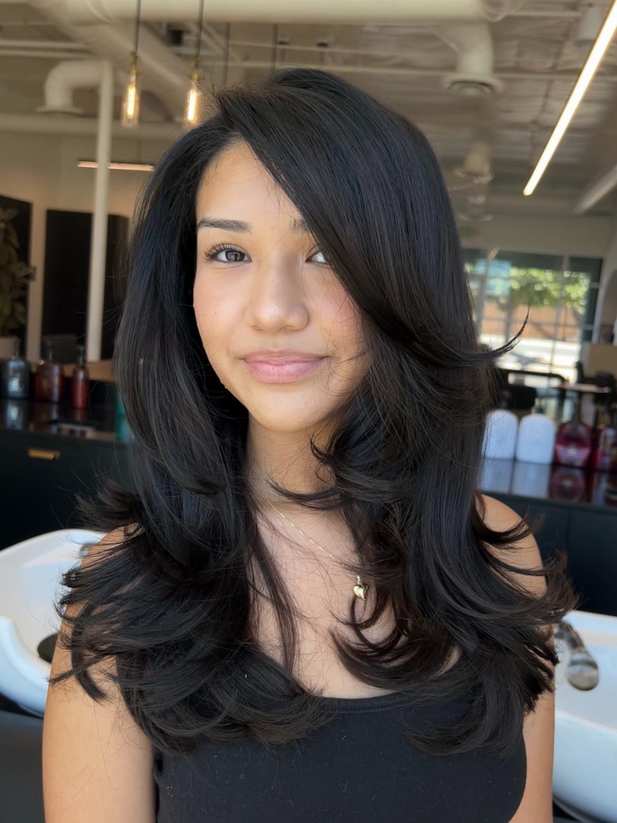 Woman wearing glossy, voluminous long layers with a deep side part