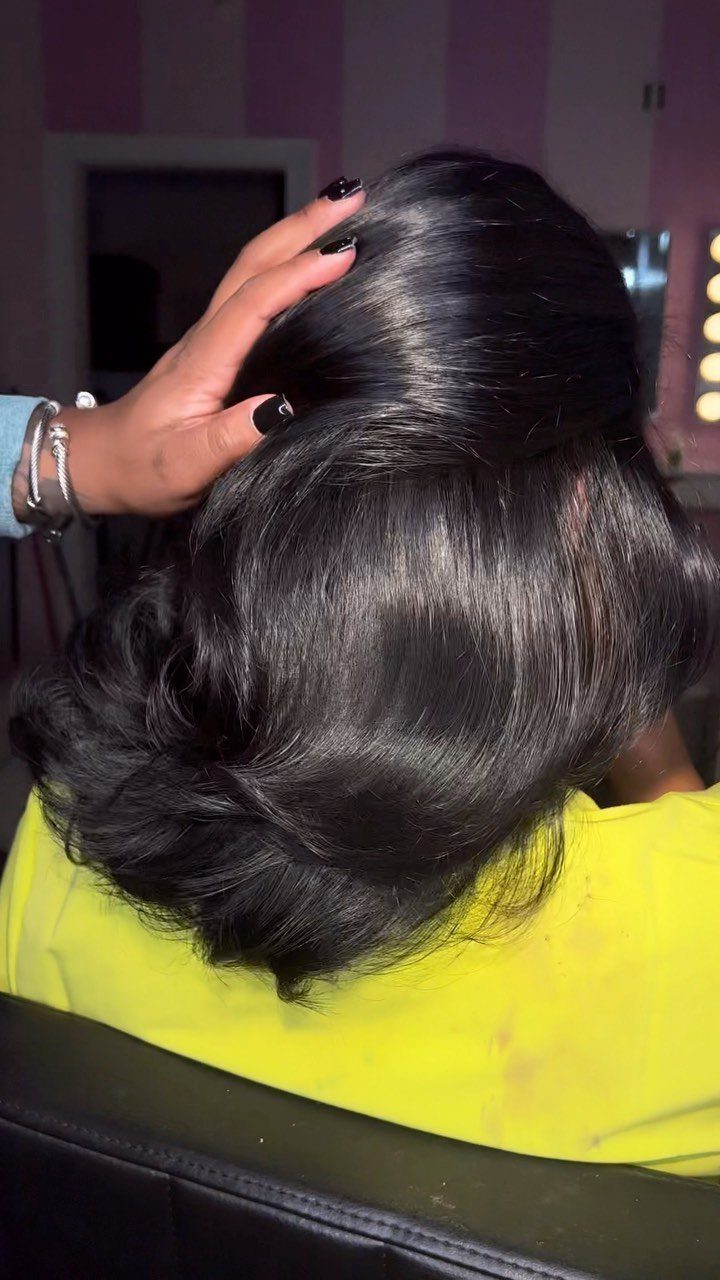 Glossy black hair styled in voluminous, smooth curls in a salon chair