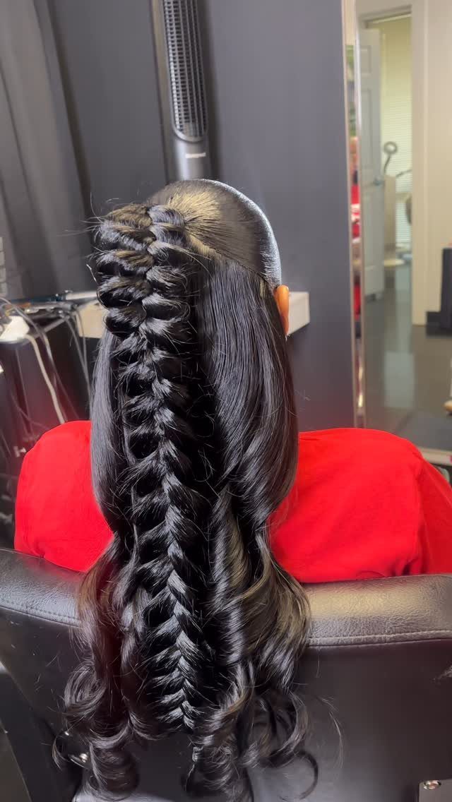 Black hair braided from the crown into a long braid with loose curled lengths