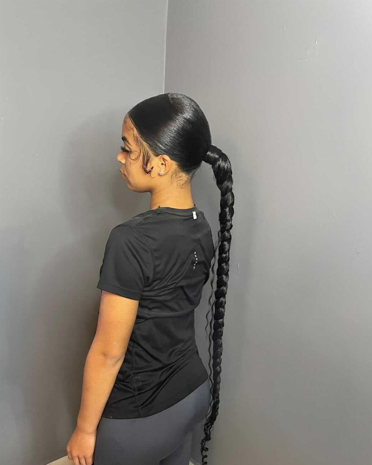 Sleek black hair gathered into a long braid from a low ponytail