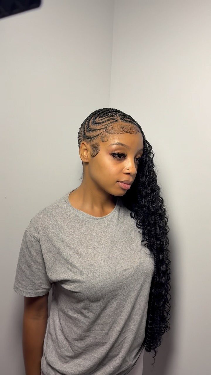Woman with side-swept black cornrows and long curls over one shoulder