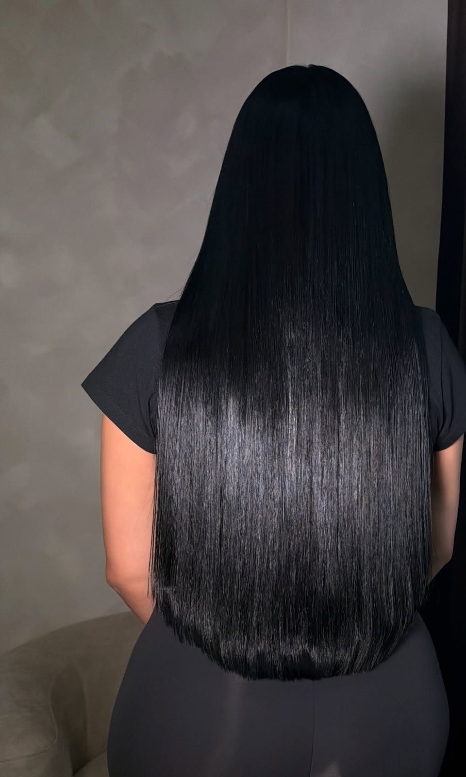 Long, straight jet-black hair falls smoothly down the back