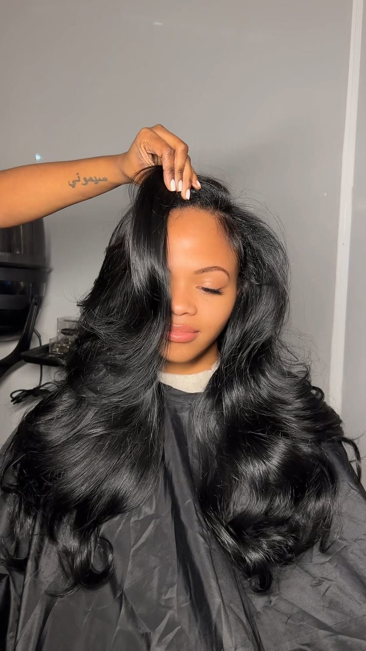 Woman showing long, voluminous black hair swept across her forehead in a side-parted style