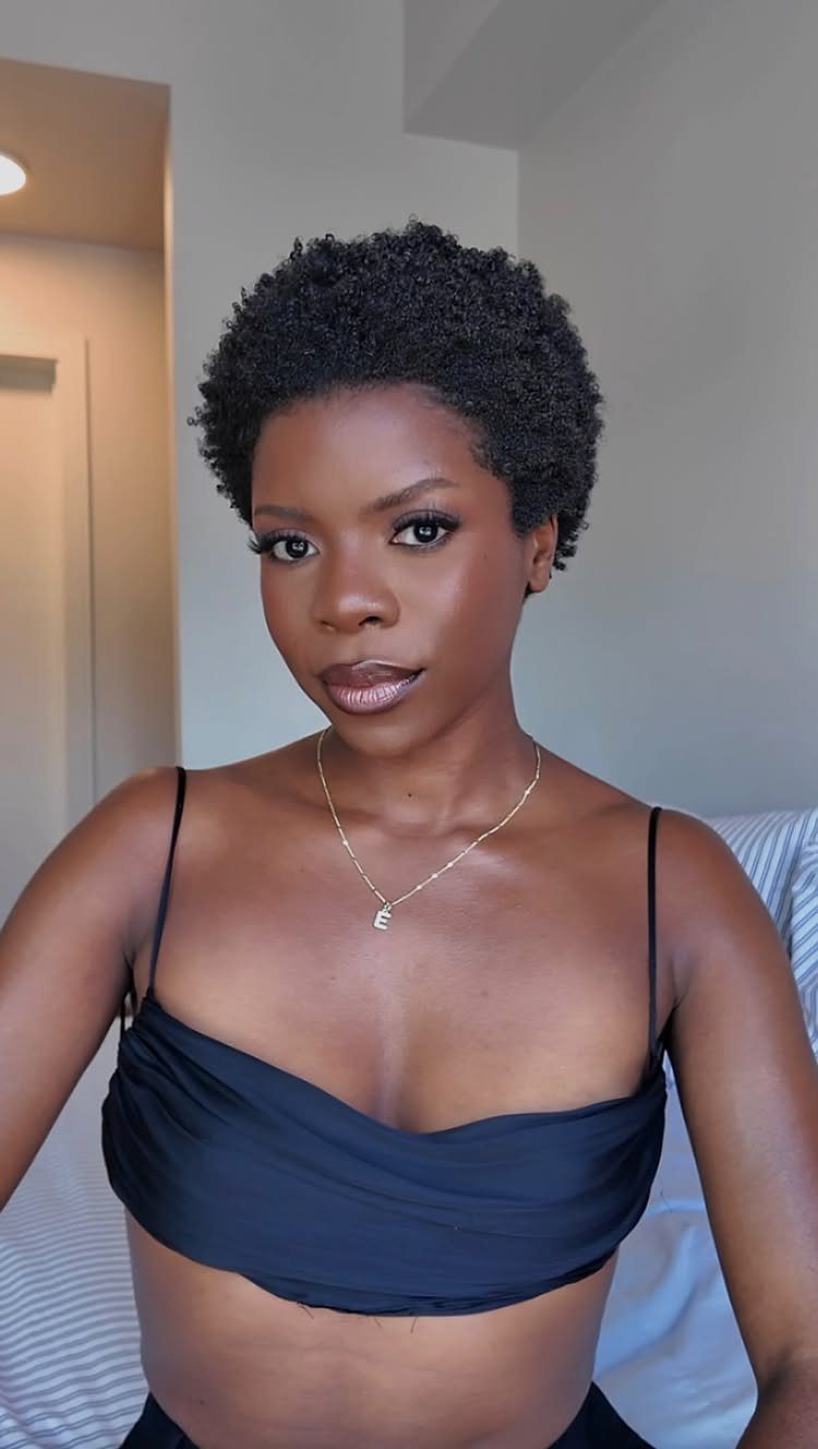 Woman wearing a short, rounded natural afro with tightly curled black hair