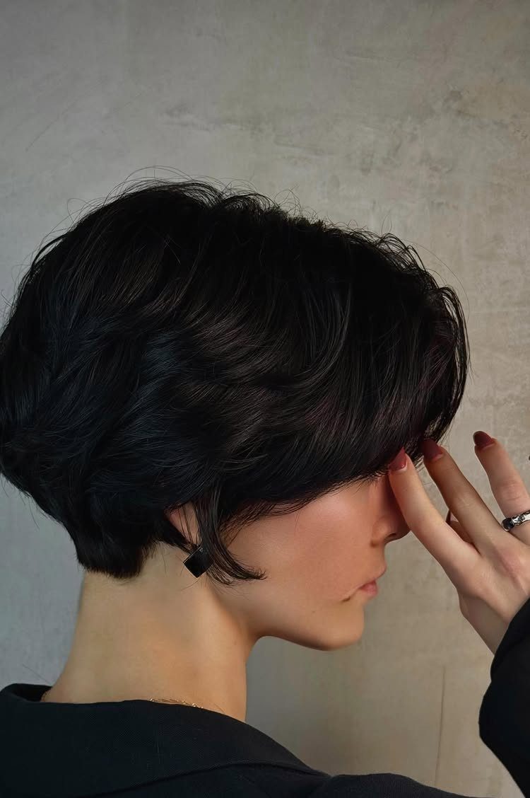 Short dark layered bob-pixie haircut shown in side profile