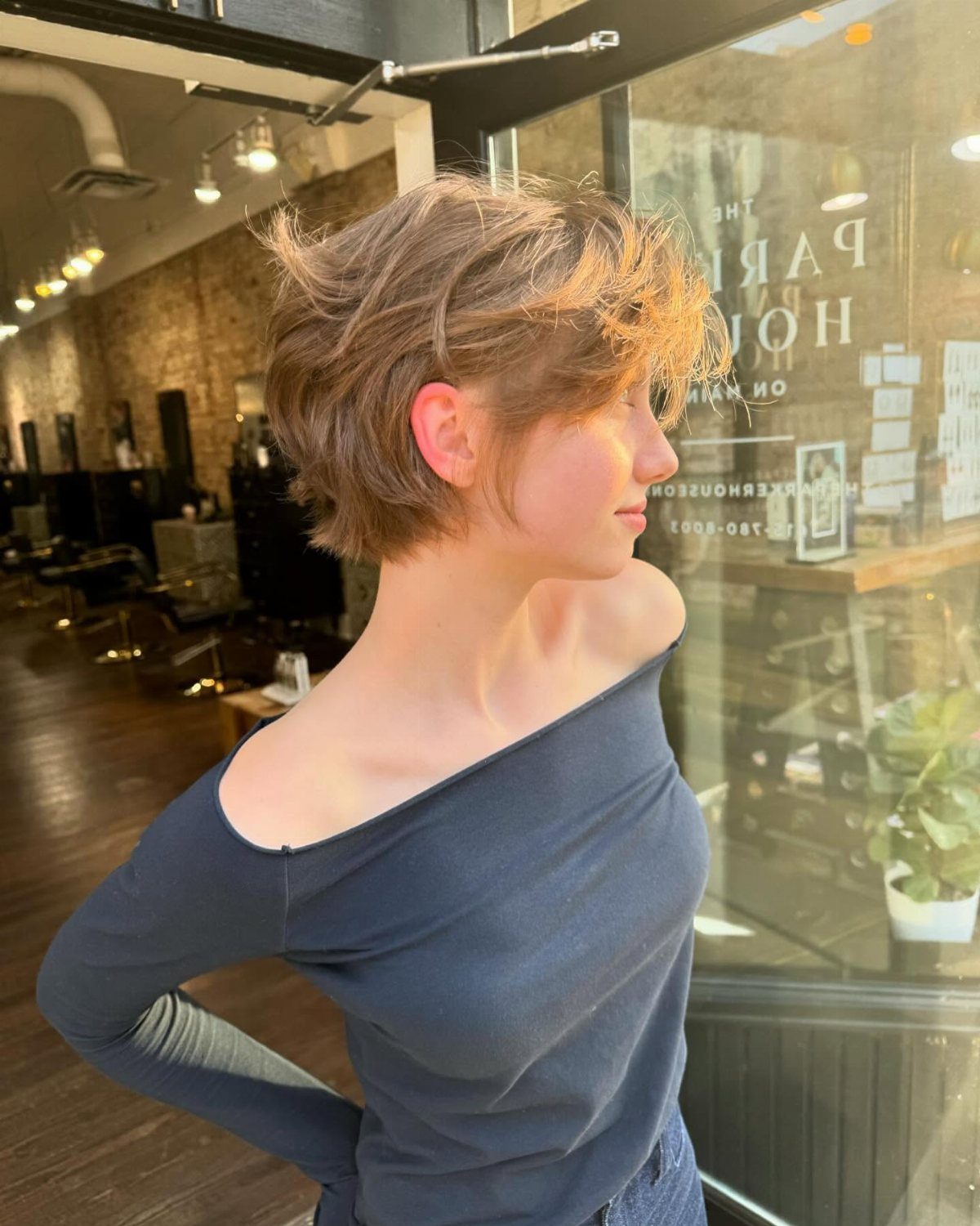 Short wavy layered crop styled tousled on a person outside a salon