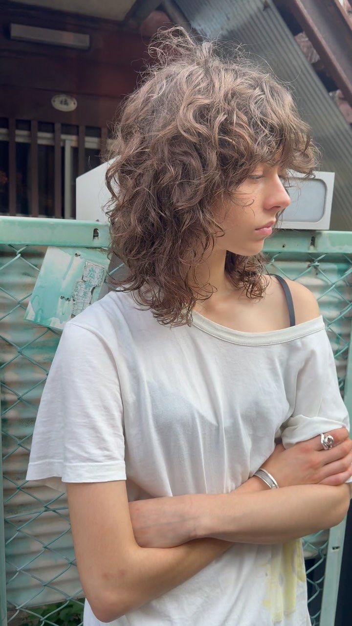 Curly wolf cut with tousled brown layers and a shaggy, longer back