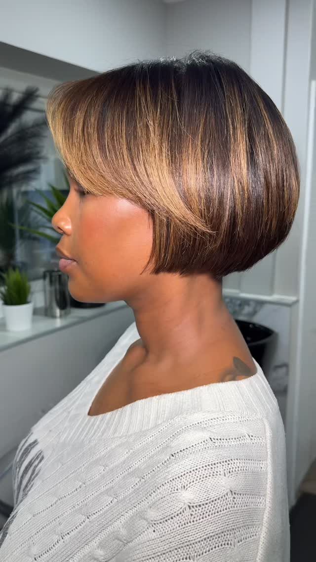 Woman showing a sleek highlighted bob with layered ends and side-swept bangs