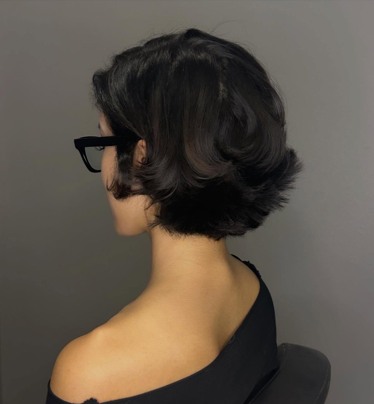 Dark layered short bob with voluminous curved ends, shown from behind