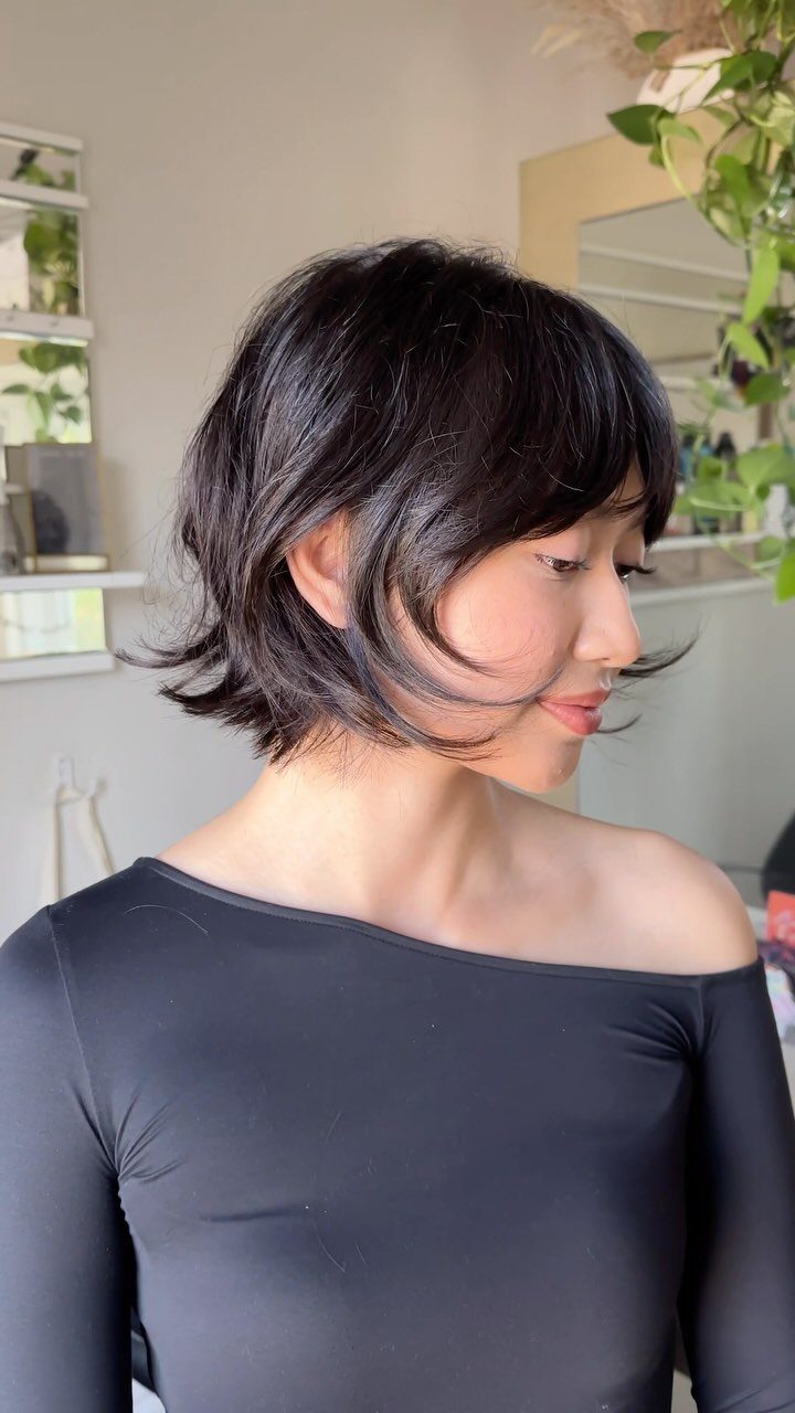 Woman showing a choppy, layered dark bob with flipped-out ends