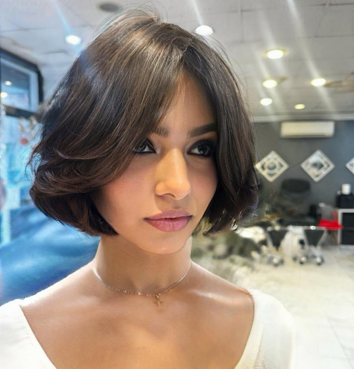 Woman wearing a polished, softly layered chin-length bob with side-swept bangs