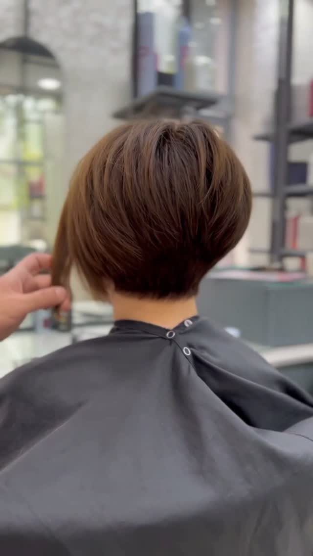 Short brown stacked bob with rounded layers tapering neatly at the nape