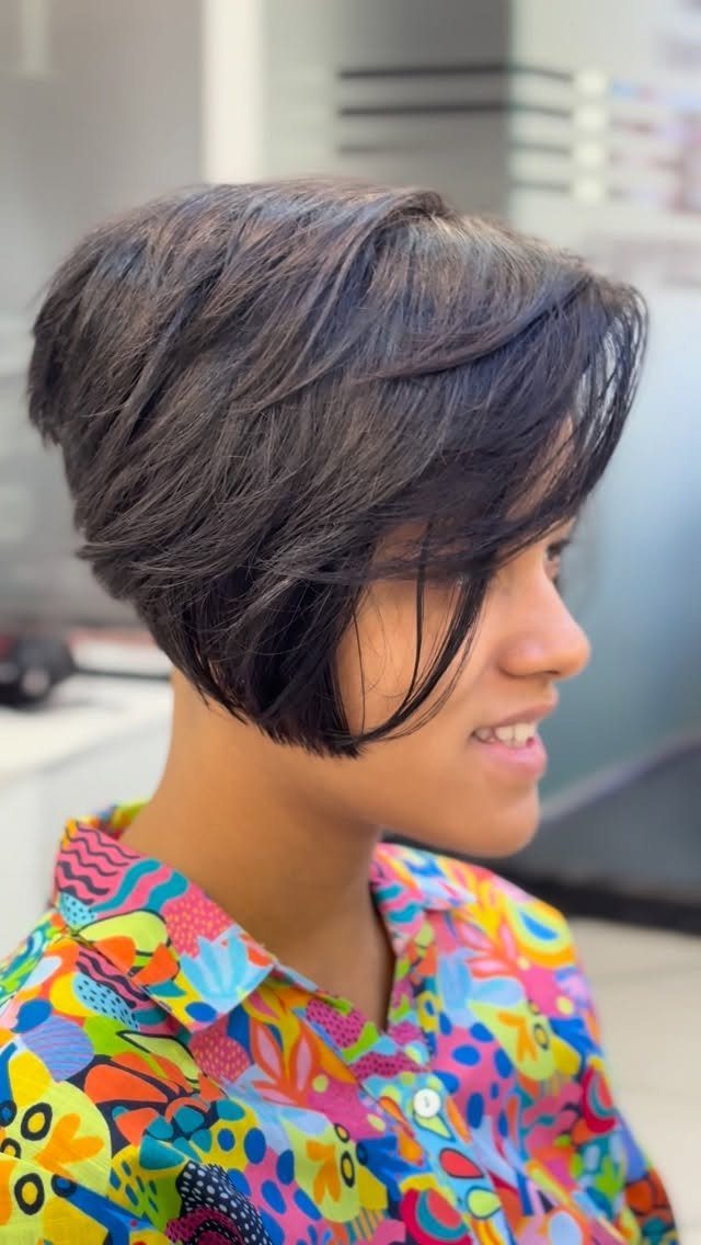 Short dark layered bob with tapered ends and face-framing pieces on a person