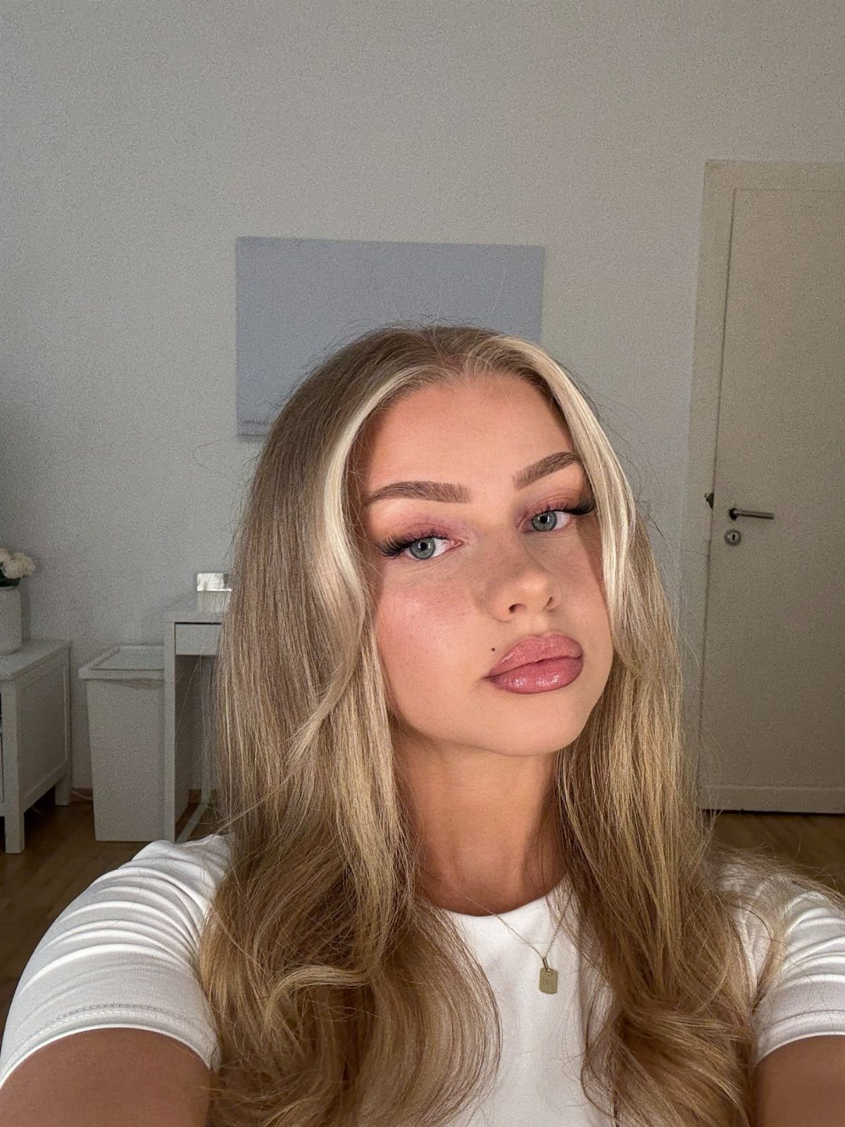 Long blonde layered hair with face-framing highlights and loose waves