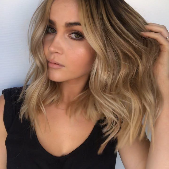 Woman showing a tousled blonde beach bob with loose waves and layered ends
