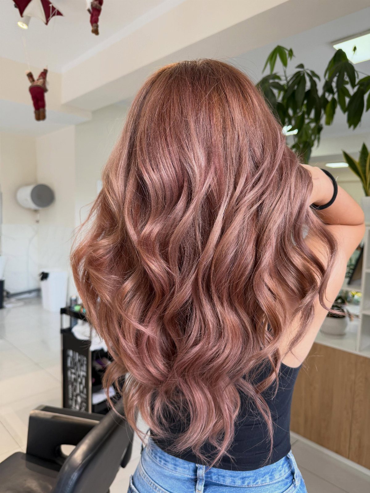 Long wavy rose-brown hair shown from behind in a salon