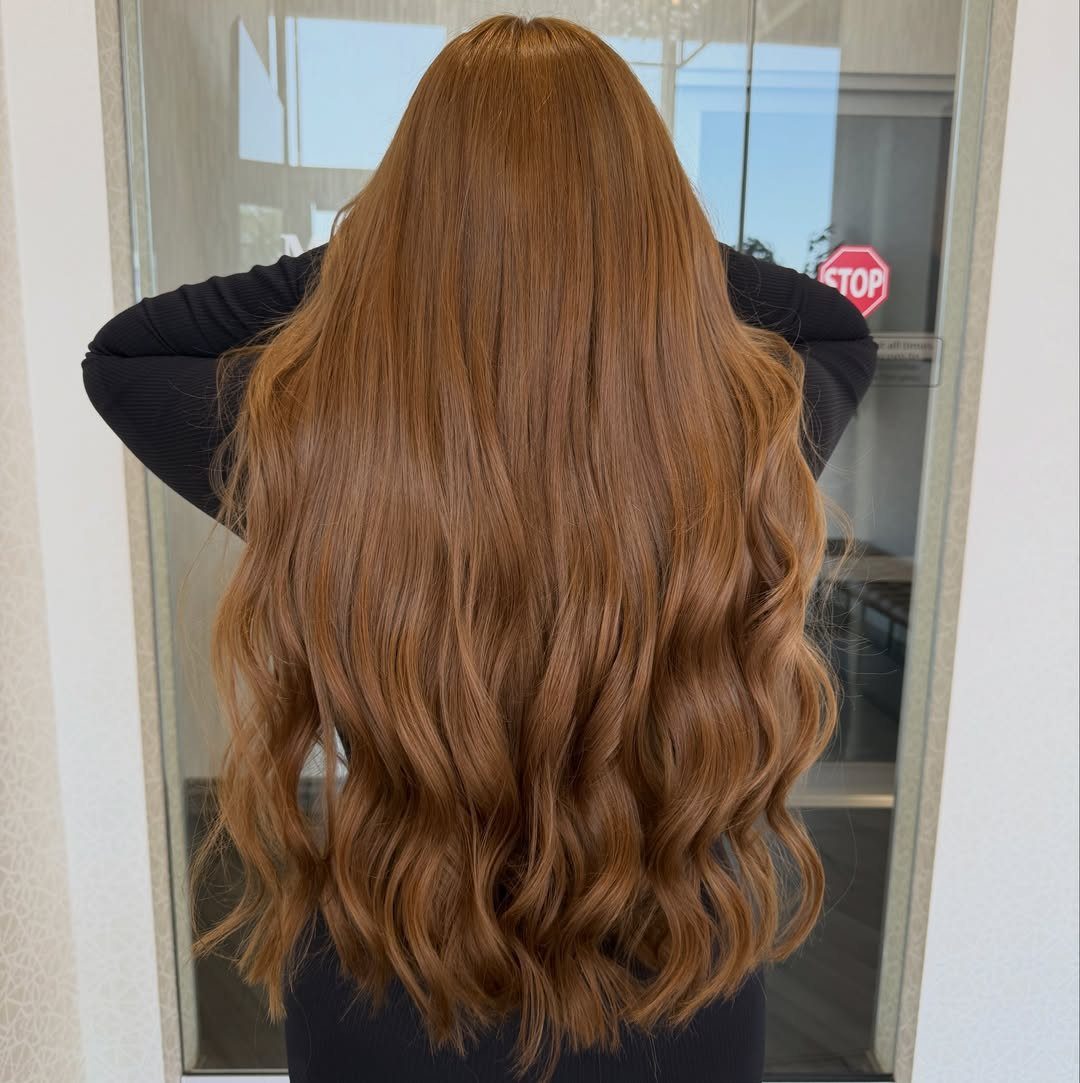 Long honey brown hair styled in loose waves from the back