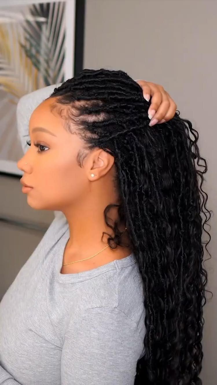 Woman holding long black braids and curls gathered at the crown