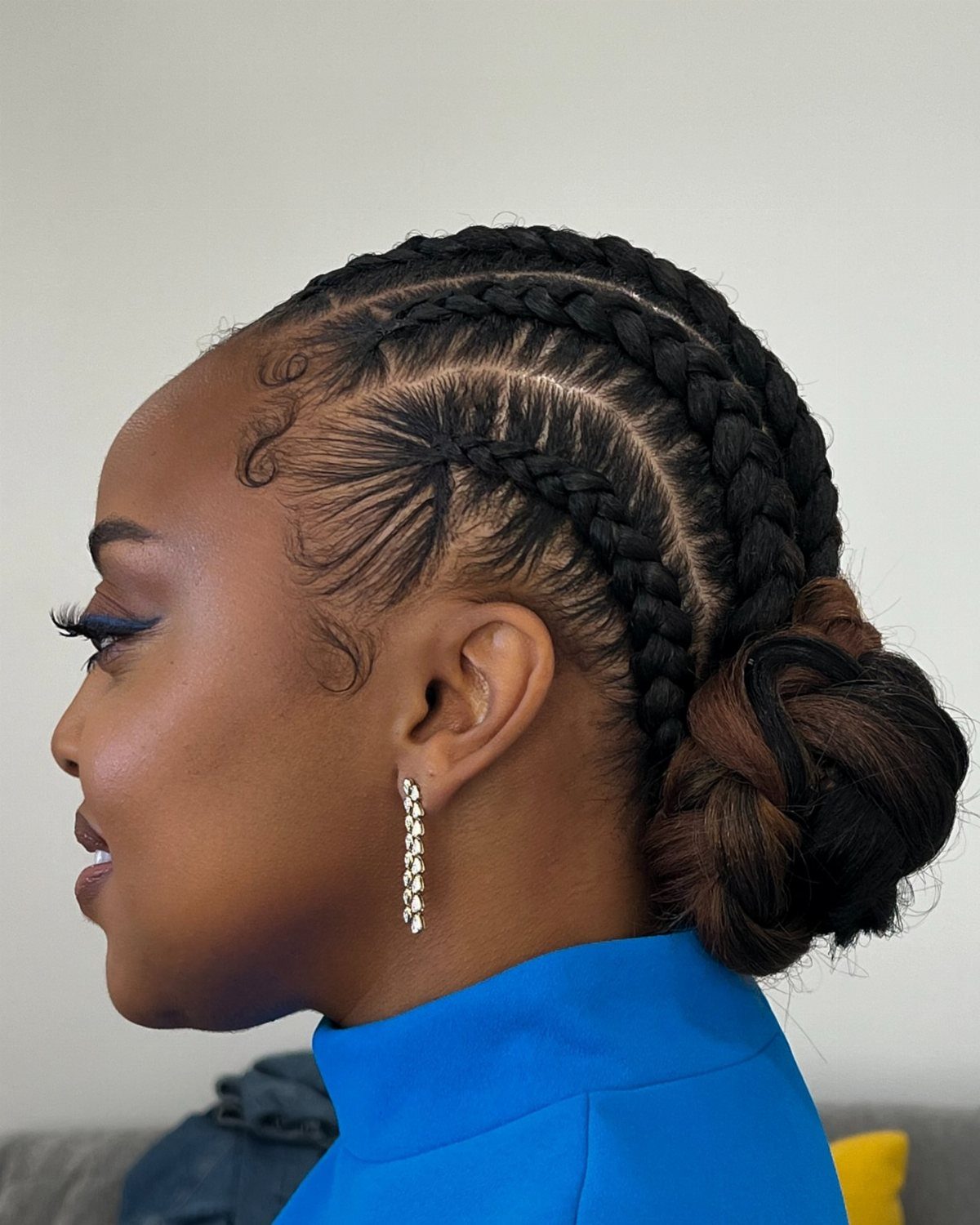 Woman wearing thick French braids gathered into a low bun