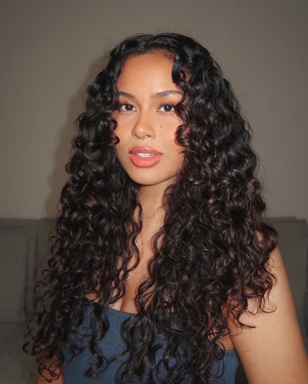 Woman with long, voluminous black curls falling past her shoulders