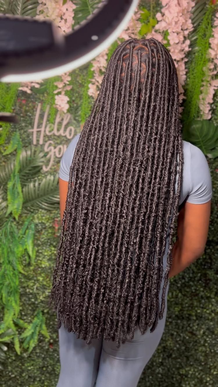 Long dark braids cascade down a person’s back to below the waist