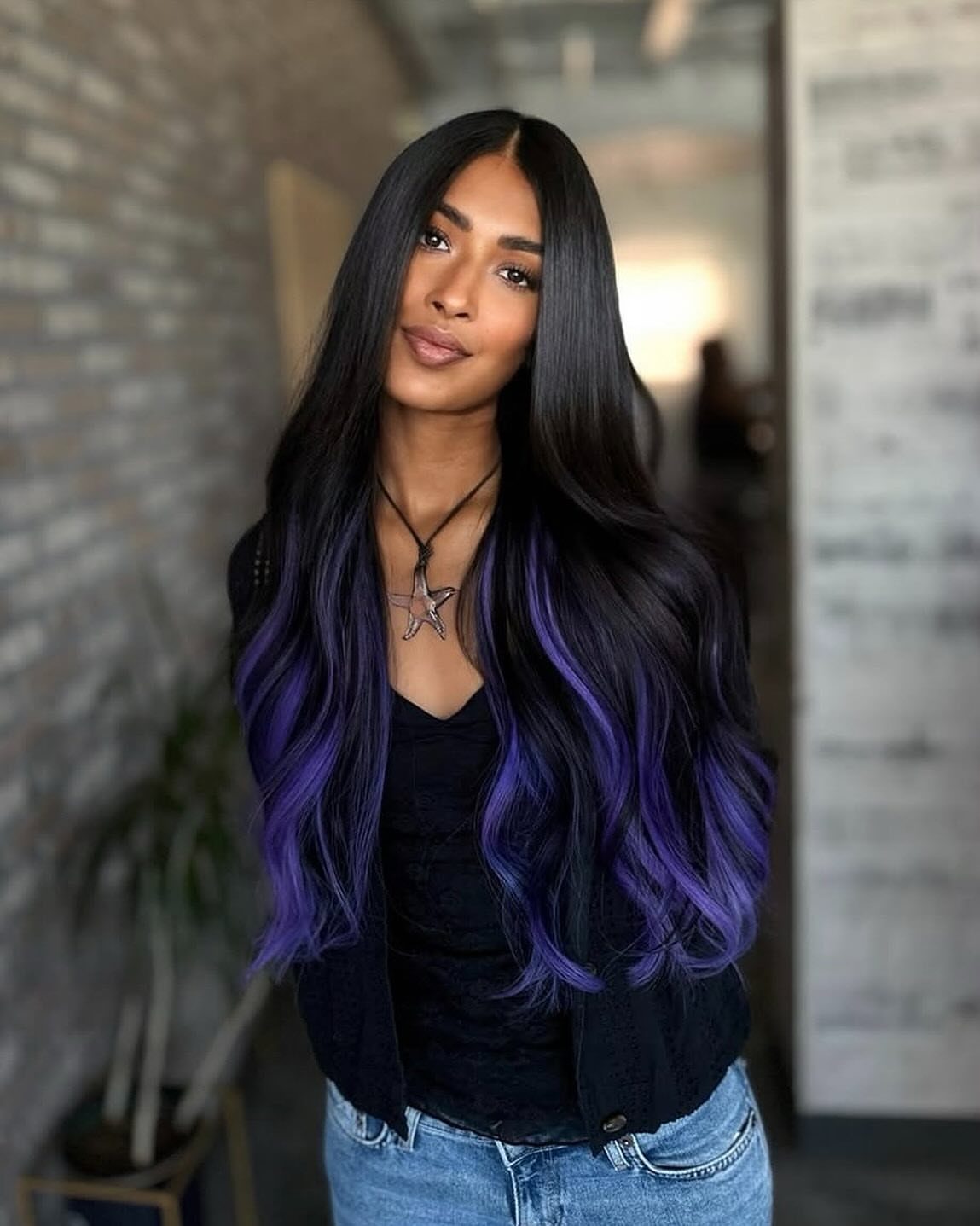 Woman with long center-parted black hair fading into purple waves