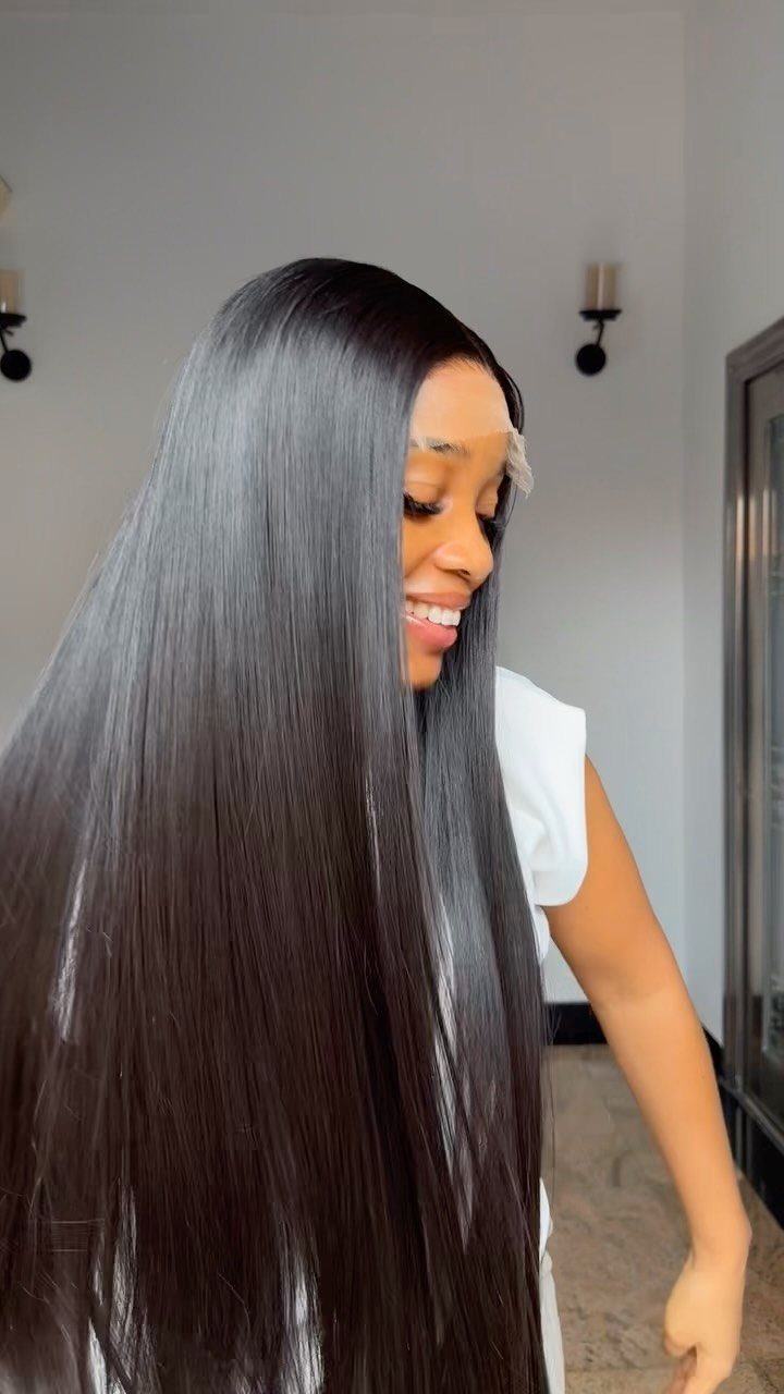 Woman showing long, smooth, shiny black hair falling straight over her shoulder