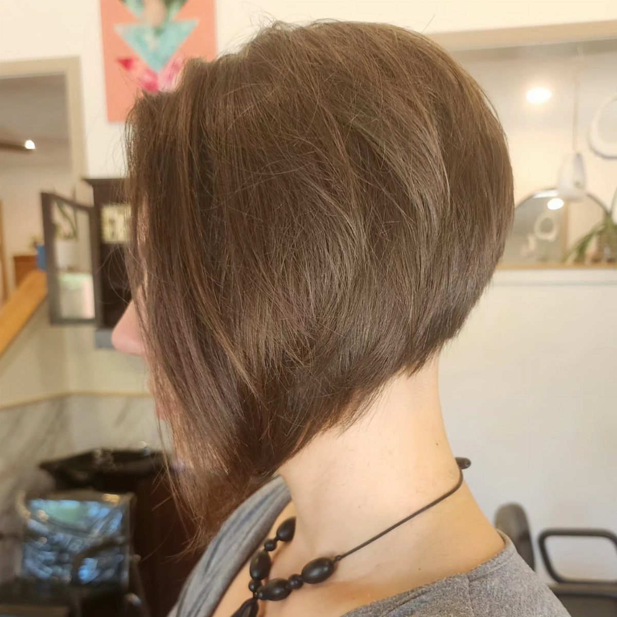 Brown inverted bob haircut with longer front layers and a shaped shorter back