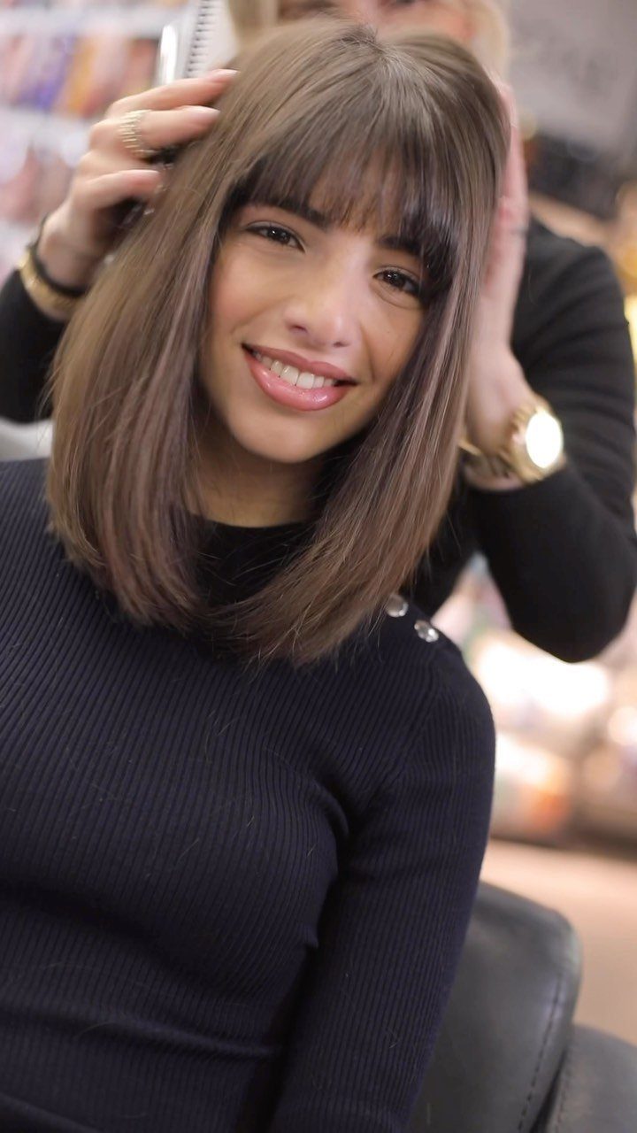 Woman showing a smooth long bob with full bangs in a salon