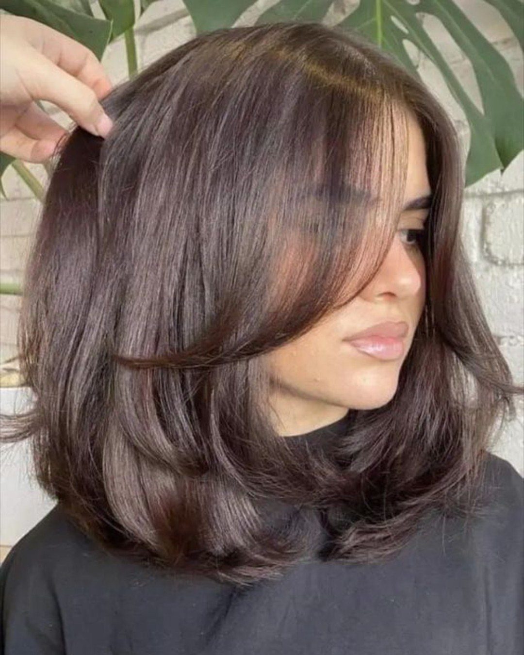 Dark brown layered lob with voluminous curled ends and face-framing pieces