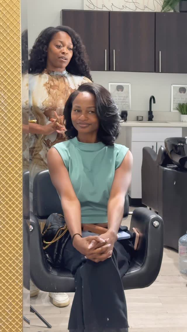 Woman with a voluminous side-parted shoulder-length bob seated in a salon chair