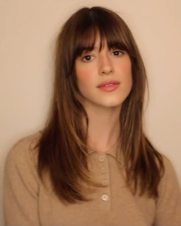 Long dark hair with face-framing layers and straight bangs