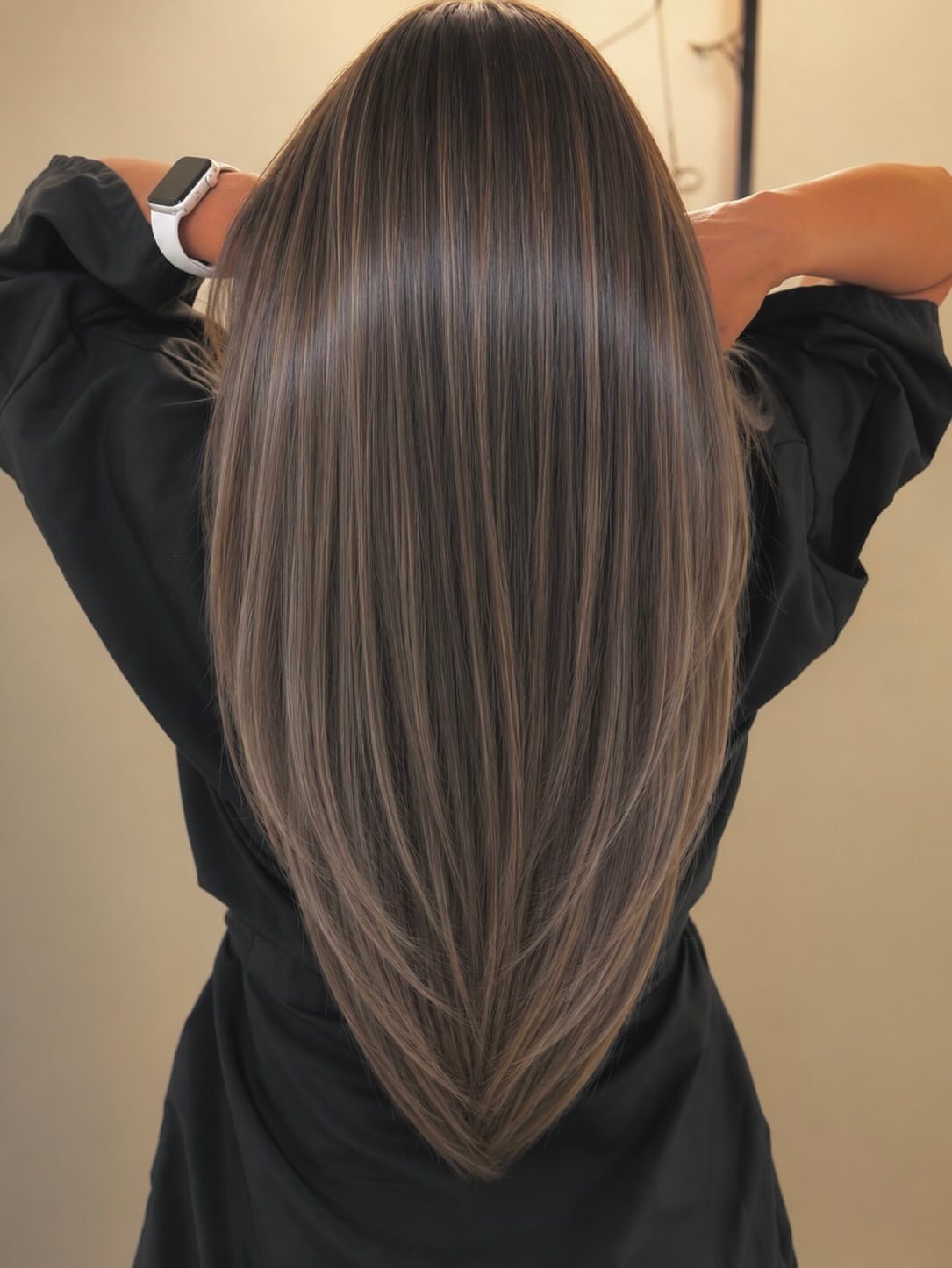 Long straight brown hair tapers into a pointed V-shaped layered cut